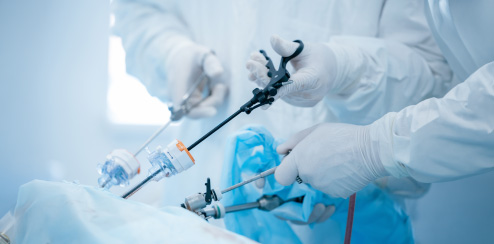 Surgeons performing advanced laparoscopic surgery using specialized instruments in a sterile environment.